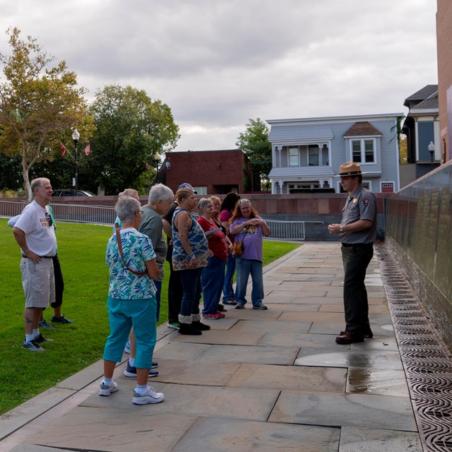 A group of people watching a ranger speak.