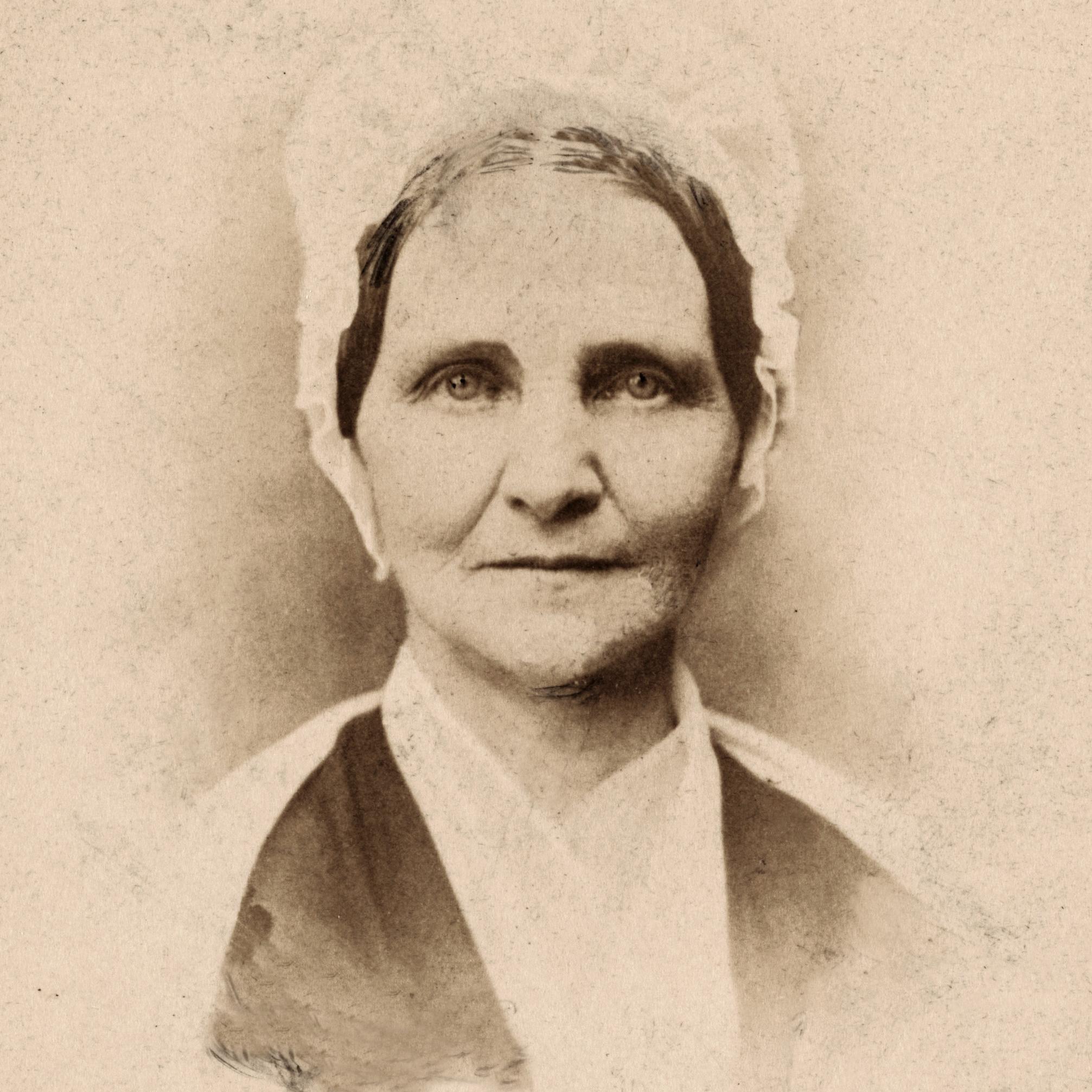 A woman in a bonnet looking directly at the camera