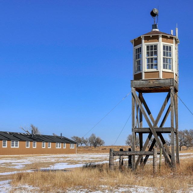 long low building with windows next to a watch tower