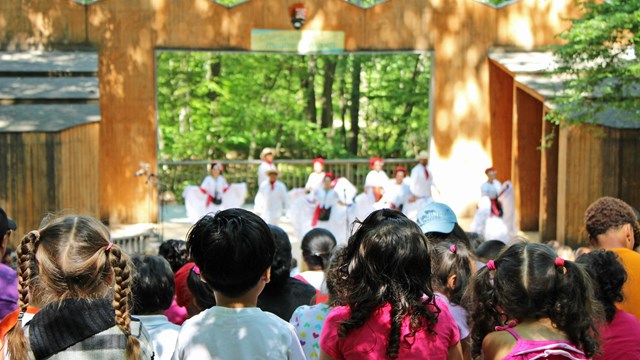 Four children watch a show at Children's Theatre-in-the-Woods