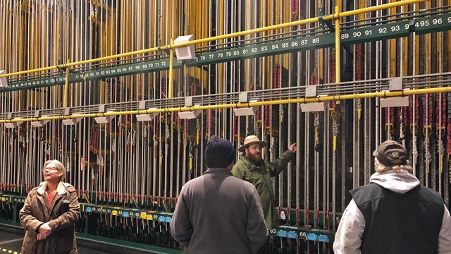 An NPS ranger explains the theater's fly line system.