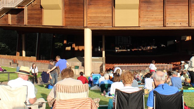 Patrons on the Lawn in chairs with Filene Center in the background