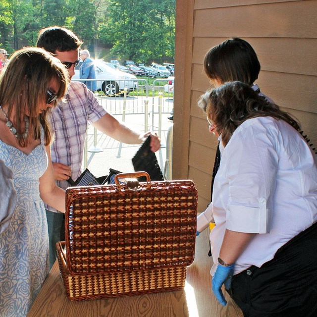 Staff members inspecting patrons cooler and bags prior to entrance at Filene Center Main Gate