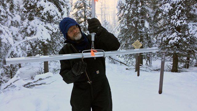 park staff conducting snow depth survey in winter.
