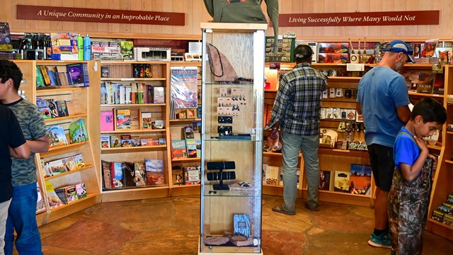 Gift shop display racks being browsed by several visitors.  