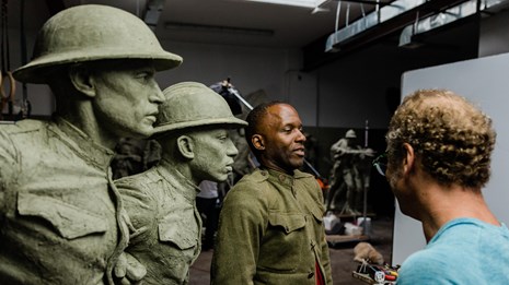 A model and sculptor work on the bas relief for the World War I Memoria.