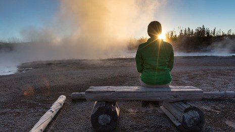 A person enjoys a sunset in the Norris Geyser Basin.