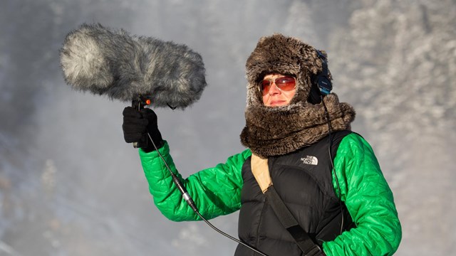 A person holds up a large microphone