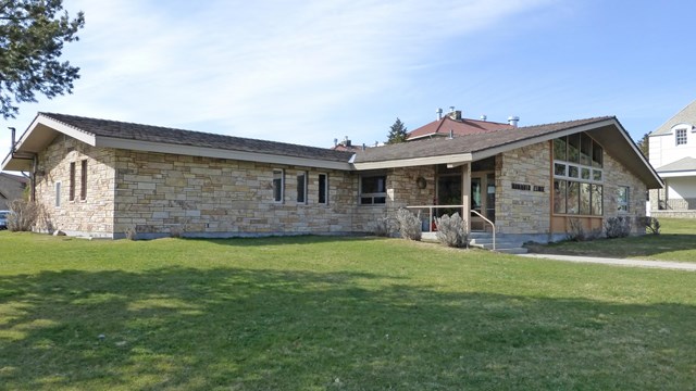 Brick building with green lawn in foreground.