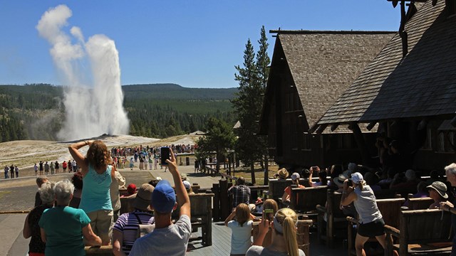 Watching Old Faithful erupt from the deck of the Old Faithful Inn