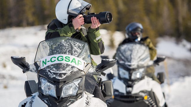 Snowmobile rider taking photo