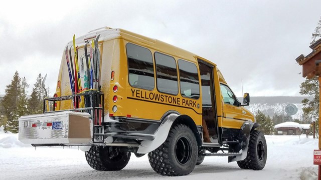 A snowcoach is loaded up with skis at Old Faithful for a day of cross-country skiing.