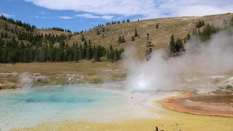 Blue and orange hot spring steams and churns.