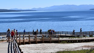 Visitors walking along the West Thumb Geyser Basin boardwalk.