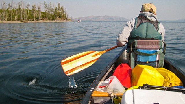 Canoer paddles on Yellowstone Lake
