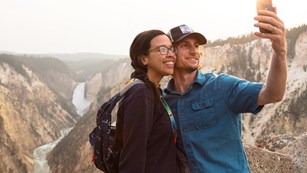 Visitors taking a safe selfie with Lower Falls of Grand Canyon in background