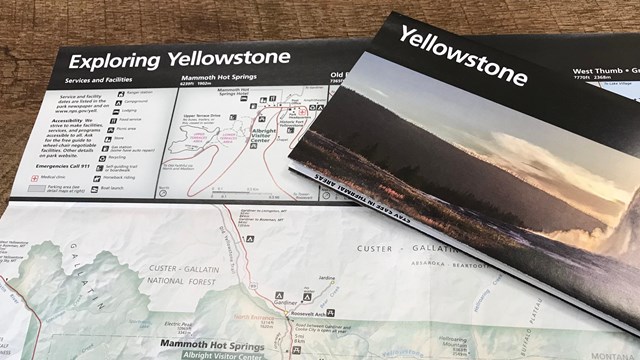 A brochure with the word Yellowstone sits on top of another unfolded brochure.