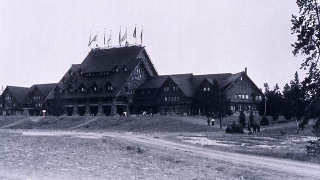 Black and white photograph of the log cabin structure of the Old Faithful Inn.