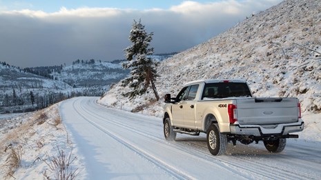 A truck driving on a snow-covered road.