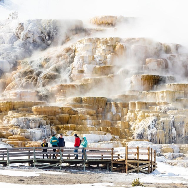 Visitors viewing a hot spring from the safety of the boardwalk.
