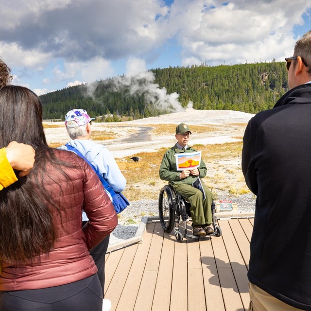 A panger gives a program on the boardwalk before an Old Faithful eruption
