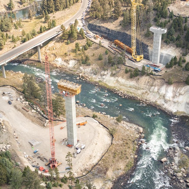 an aerial view of a construction site of a new bridge near a river.