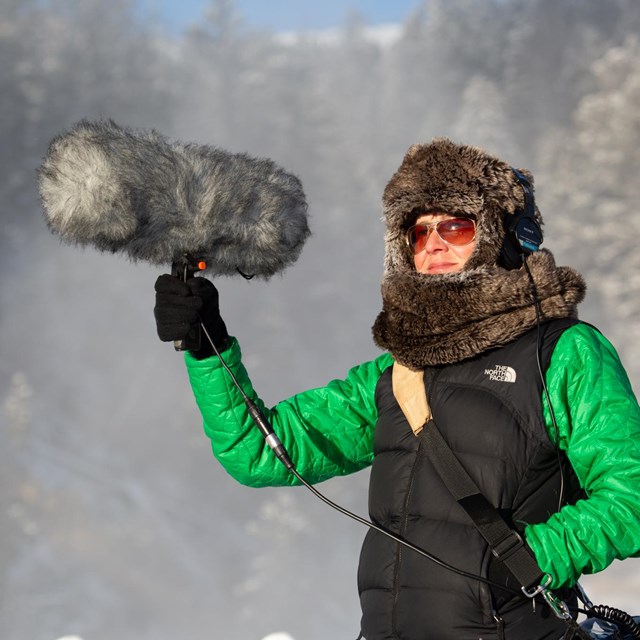 A person holds up a large microphone