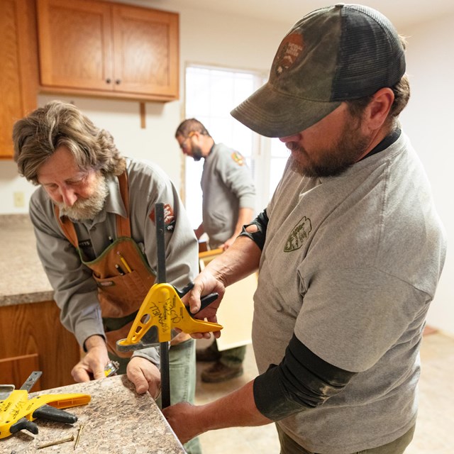 Park carpenters working on cabinets and shelving.