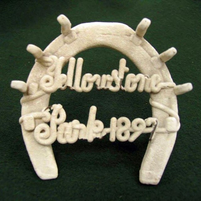 A horseshoe covered in white rock reads 