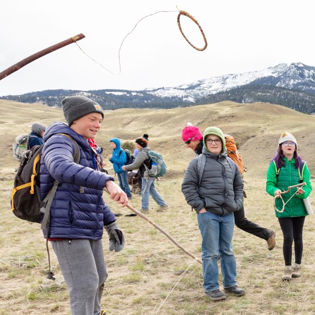 Students play a traditional Native American game outside.