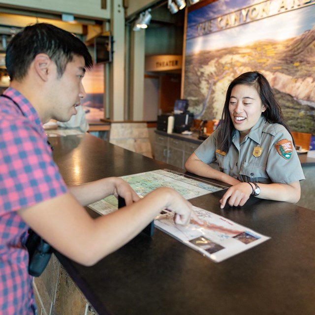 Ranger giving information to a visitor at a desk