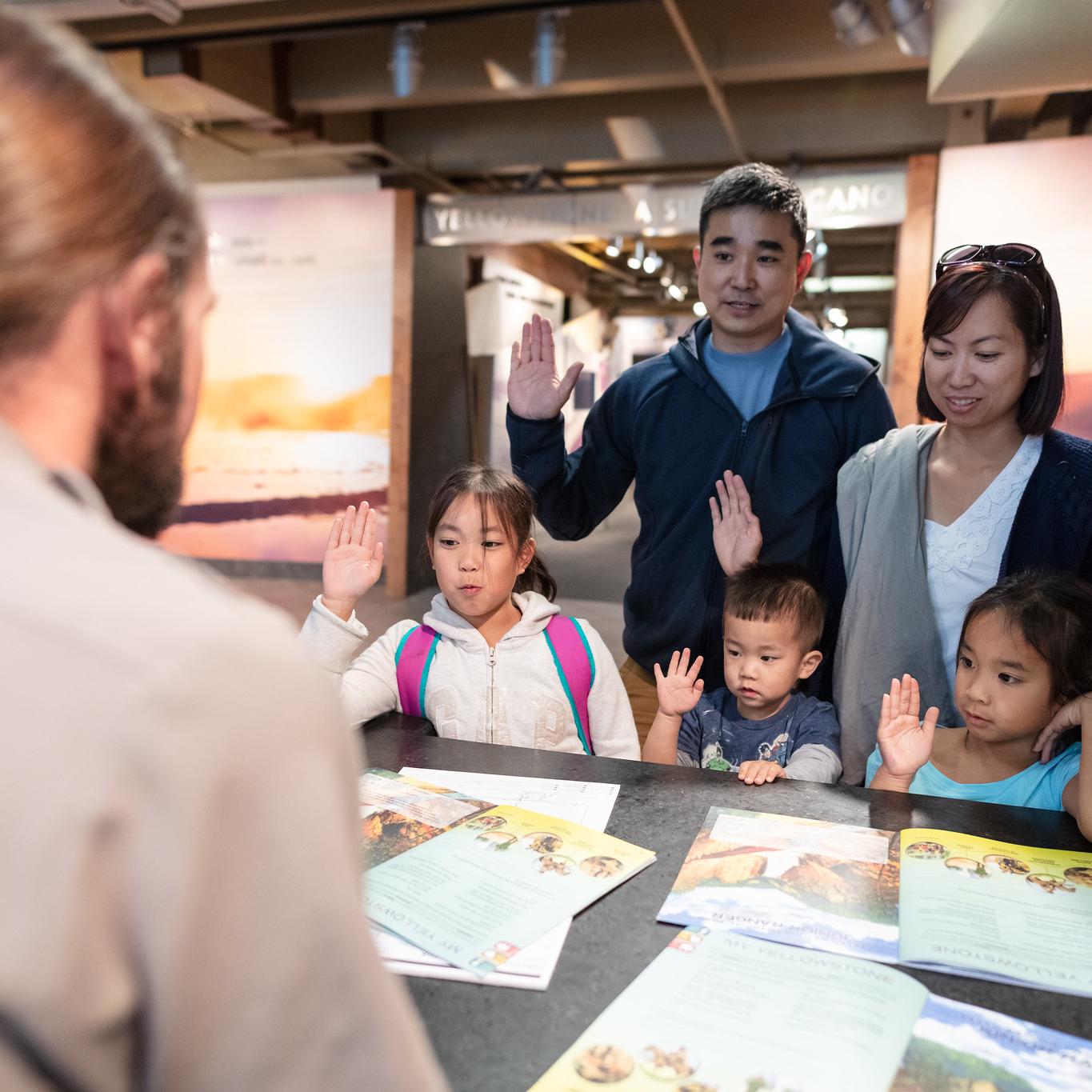 A family get a junior ranger badge from a ranger.