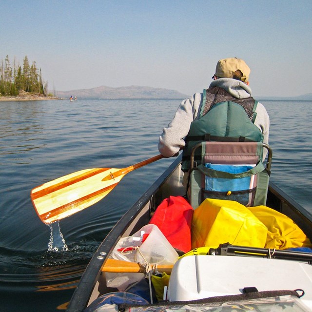 Canoer paddles on Yellowstone Lake