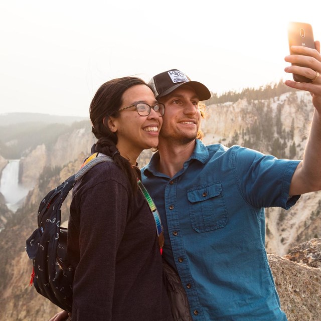 Visitors taking a safe selfie with Lower Falls of Grand Canyon in background