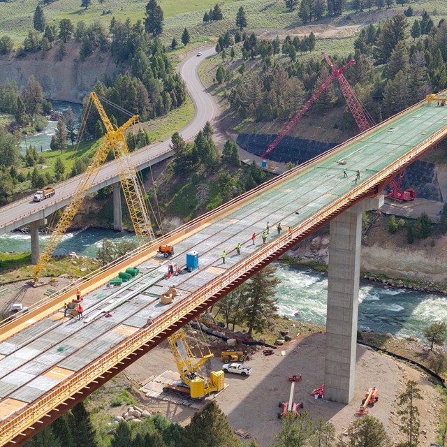 An aerial view of a large bridge being built over a river canyon