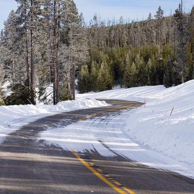 A road with a snowdrift partially covering it