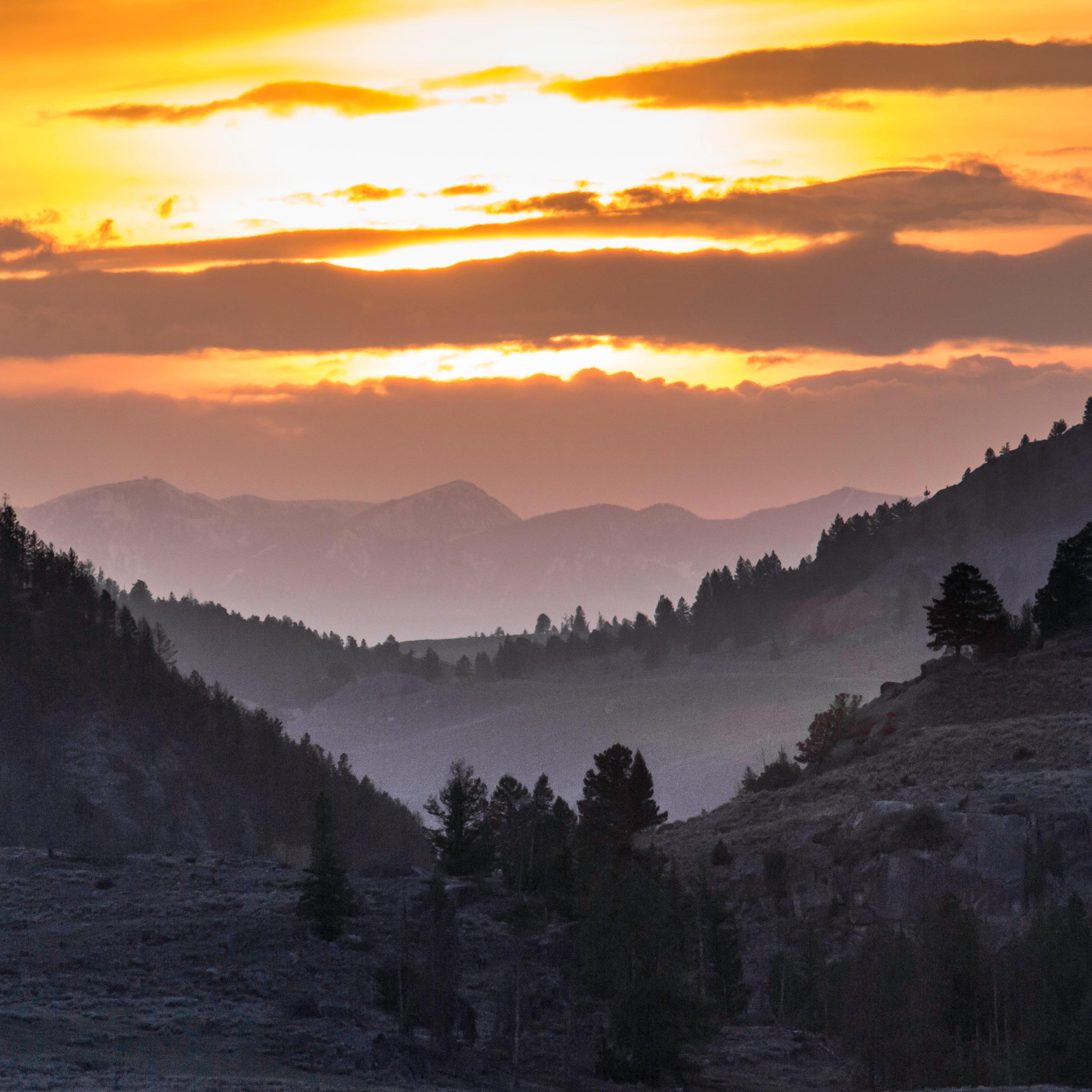 Evening sunset colors rain falling an orange color with a mountain ranger in the background