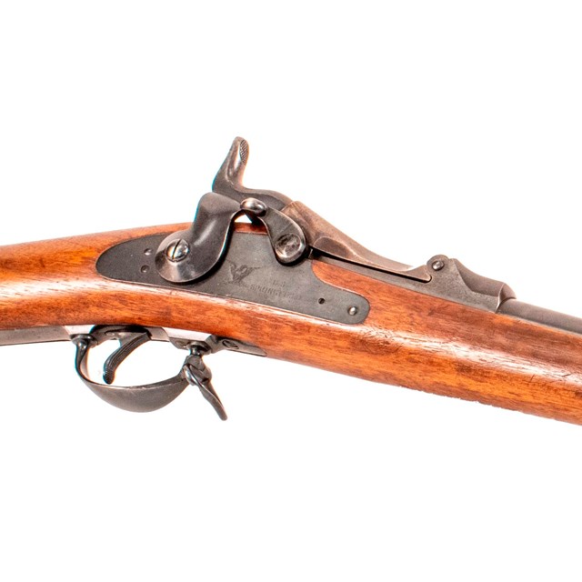 Large brown colored rifle with metal attachments