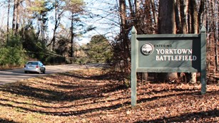 Car driving Colonial Parkway past sign that says,