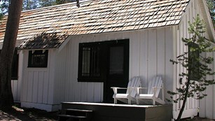 A white-painted cabin with dark shutters at White Wolf Lodge.