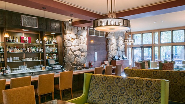 Brightly lit indoor bar space with couches and dining tables.