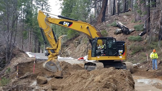 Machine moving dirt in roadbed