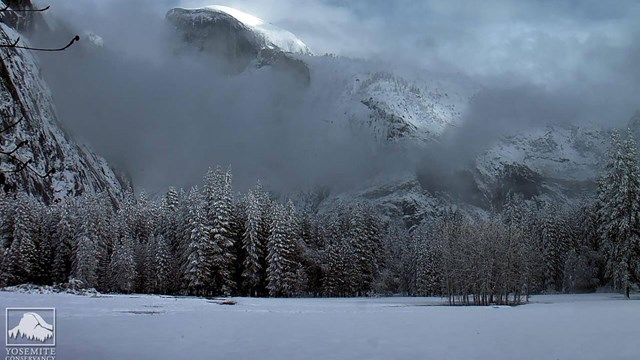 Snowy and cloudy view of Half Dome