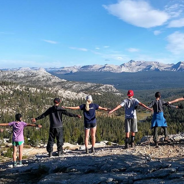 Naturebridge student class holding hands in a chain on a hike