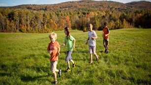 Kids running through a field.