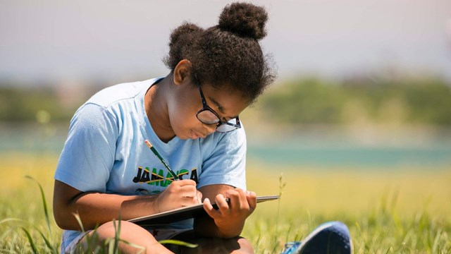 Girl writing in notebook. 