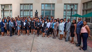 Large group of HBCUI students pose for group photo in business professional attire.