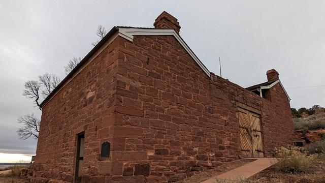 A stone building stands before a gray sky