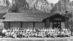 A large group of people sits in front of the Zion Nature Center in 1989.