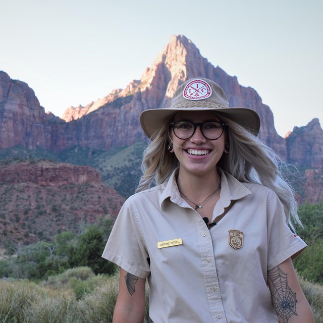 Ranger stands in front of Zion cliffs